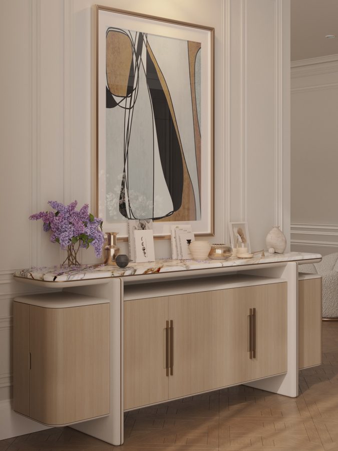 Close-up of an elegant console with marble top, abstract artwork, and lilac flowers — a refined decorative corner by Maison Révèle with warm neutrals and golden accents.